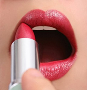 Beautiful girl applying red lipstick, silver holder